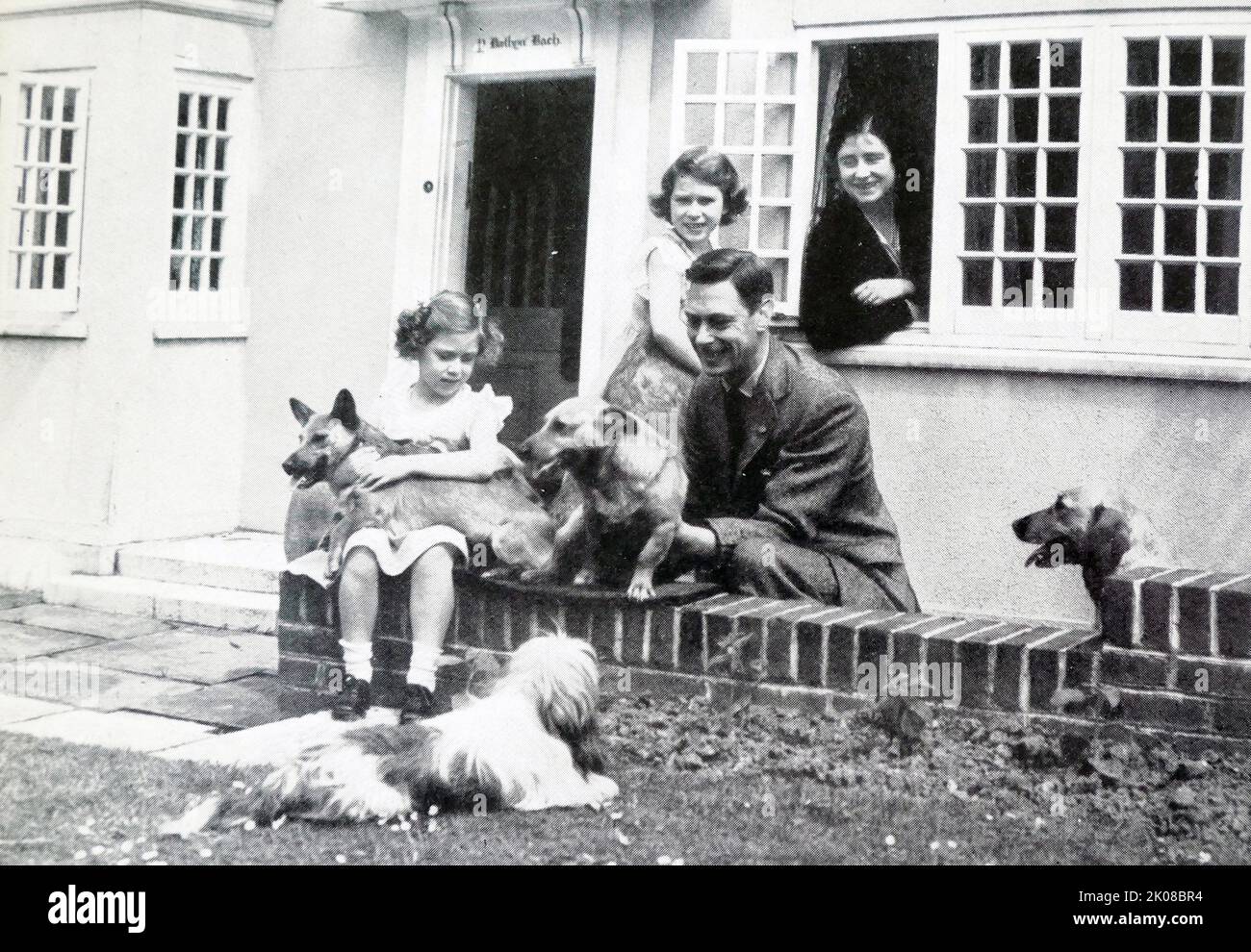 Prinzessin Elizabeth mit ihrer Familie und ihren Hunden in Y Bwethyn Bach (das kleine Haus), die ihr von den Einwohnern von Wales geschenkt wurde. Elizabeth II. (Elizabeth Alexandra Mary; geboren am 21. April 1926) ist Königin des Vereinigten Königreichs und 14 anderer Commonwealth-Bereiche Stockfoto