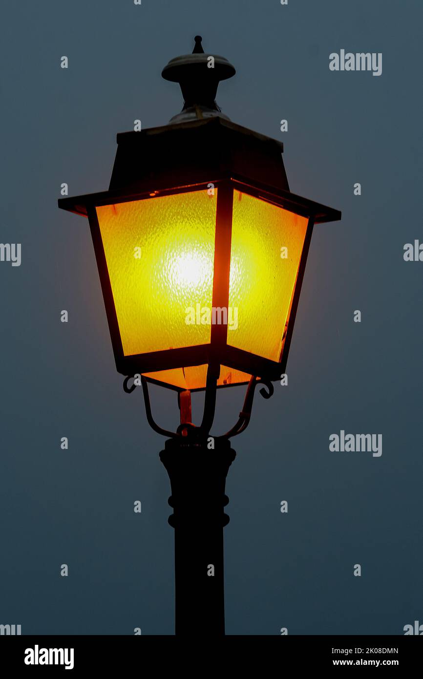 Lamppost beleuchtet mit einem weichen orangefarbenen Licht. Stockfoto