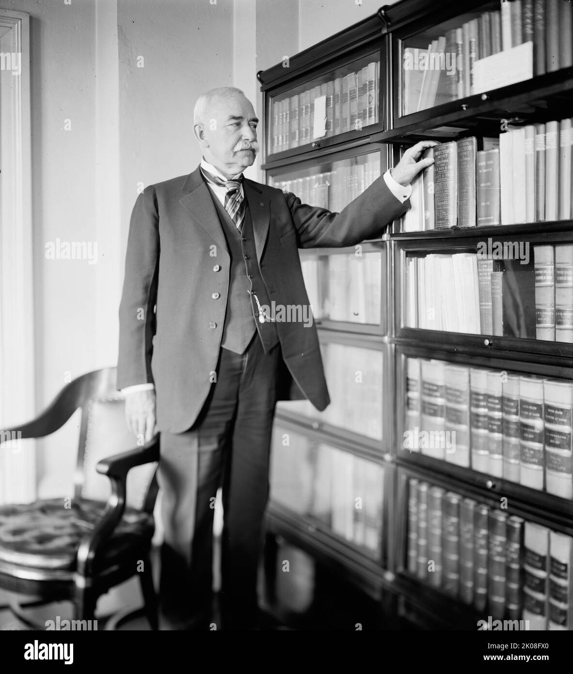 G.M. Saltzgaber, [Washington, DC?], zwischen 1914 und 1920. [Mann mit der Hand auf einer Kopie von 'Boyd's Directory, District of Columbia, 1914', veröffentlicht von Polk &amp; Co]. Stockfoto