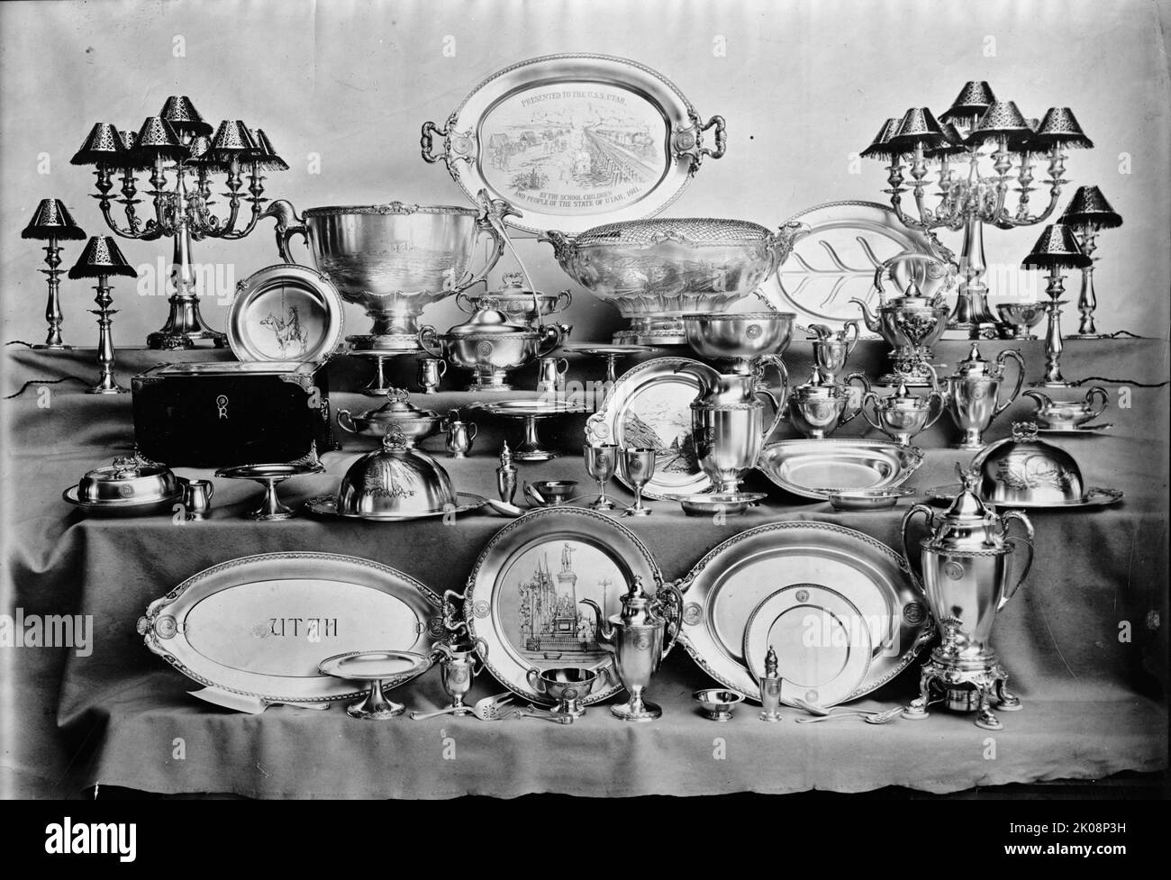 Silber gehört zu U.S.S. Utah, 1911. Silbergeschirr aus dem US-Kriegsschiff. Dekorative Kerzenleuchter, Krüge, Salben, Serviergeschirr, Heißwasserfass, Tee- und Kaffeekannen, Punchbowl und Schöpfkelle, wahrscheinlich von Gorham Manufacturing Co. Hergestellt Utah von der Schule Kinder und Menschen des Staates Utah, 1911']. Stockfoto