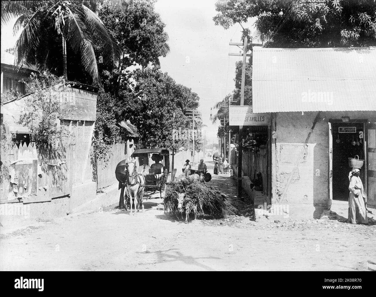 Haiti. Szene, Port Au Prince, 1911. ['Epicerie...pour les familles' - (Lebensmittelgeschäft der Familie). Beachten Sie, dass eine Frau den Korb auf dem Kopf trägt]. Stockfoto