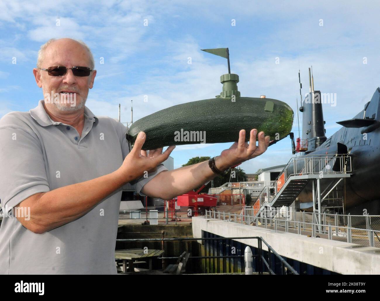 Es gab nur eine Sache zu tun, als ein eifriger Gärtner und Modellbauer in seinem Gemüsegarten eine riesige Zucchini fand...... aus ihr ein U-Boot machen. Der 65-jährige Eric Rayment, der als Freiwilliger am HMS Alliance Submarine Museum in Gosport, Hampshire, arbeitet, kam bald zur Arbeit und in nur wenigen Stunden wurde HMS Courgette ins Leben gerufen. Die neueste Ausgabe der Flotte ist satte 17' lang und 5' im Durchmesser. Bald fügte er ein wenig alte Pfeife unter seinem Waschbecken hinzu, um den Turm zu machen. Eric sagte: „Als ich es auswählte und auf den Tisch legte, fiel es mir einfach auf, dass es ein perfektes U-Boot und machen würde Stockfoto