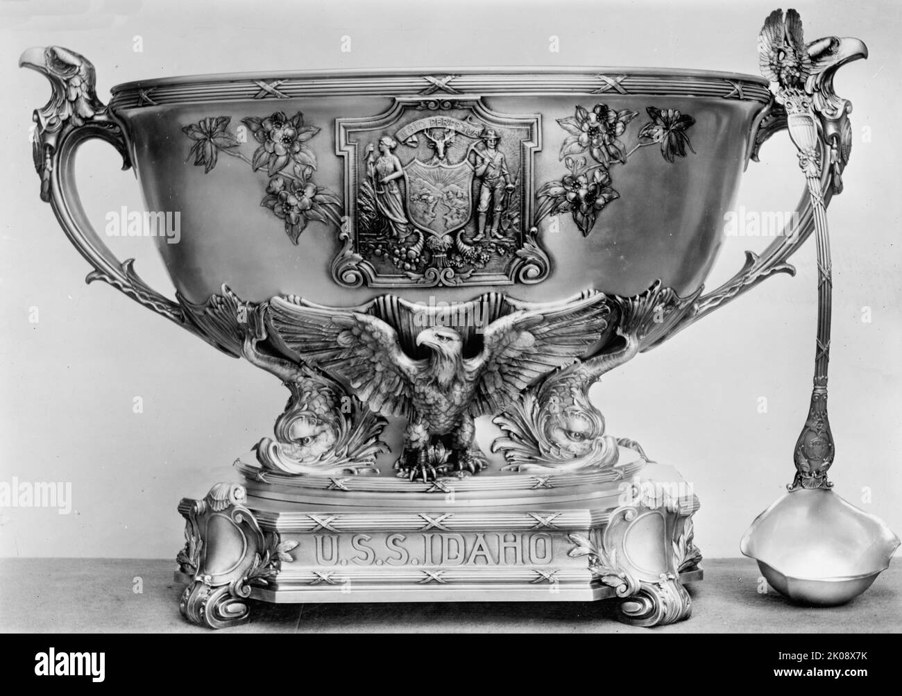 Silver Service of U.S.S. Idaho, 1912. [Silbergeschirr aus dem US-Kriegsschiff. Dekorative Punchbowl und Schöpfkelle mit Adlern, Delfinen und Plakette: „Esto Perpetua – (möge sie (Idaho) ewig bestehen) – Motto des Staates Idaho. 'Punch Set "Idaho" - Schüssel mit 75 Pints, z. B. Länge 31 Zoll; Plateaulänge 18 1/4 Zoll, Schöpfkelle, Höhe über alle 19 3/8 Zoll. Gorham Manufacturing Co“]. Stockfoto