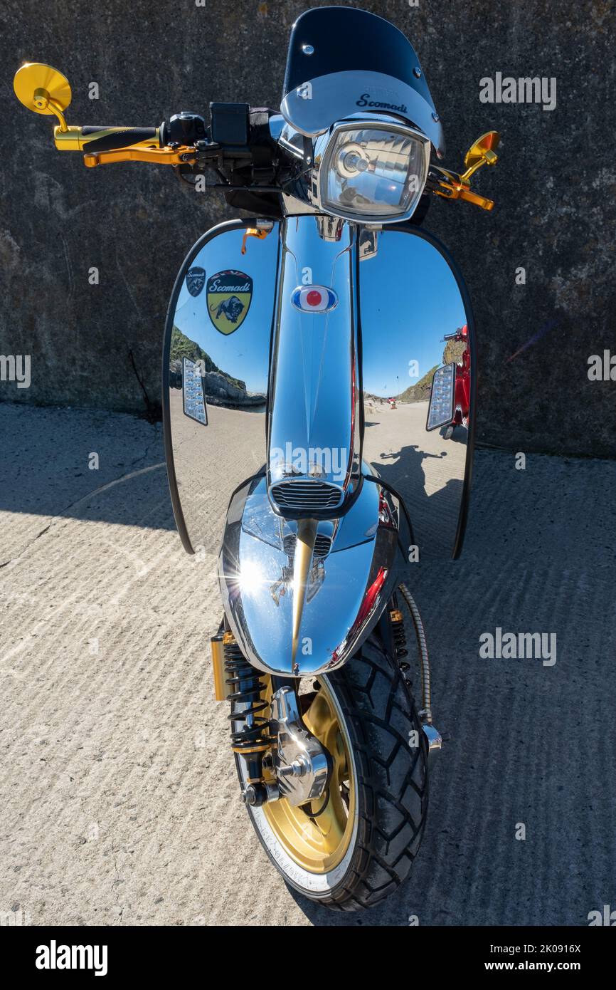 Scomadi Scooter Retro-Design mit glänzendem Chrom bei Sonnenschein im Spätsommer. Gathering of the Clans Rally, Ballintoy, Großbritannien - 10. September 2022. Stockfoto