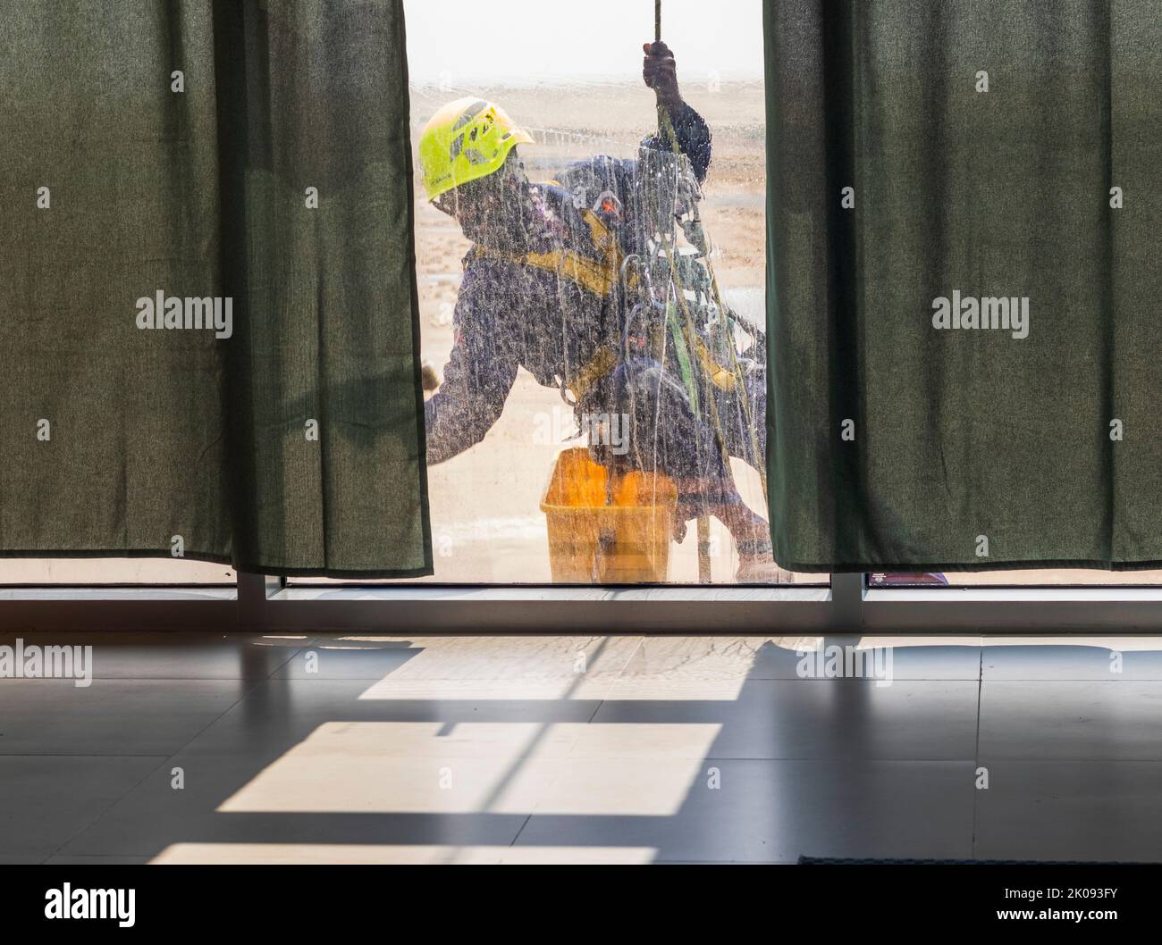 Silhouette eines Seilzugangs Glasreinigers, der in der Höhe arbeitet. Stockfoto