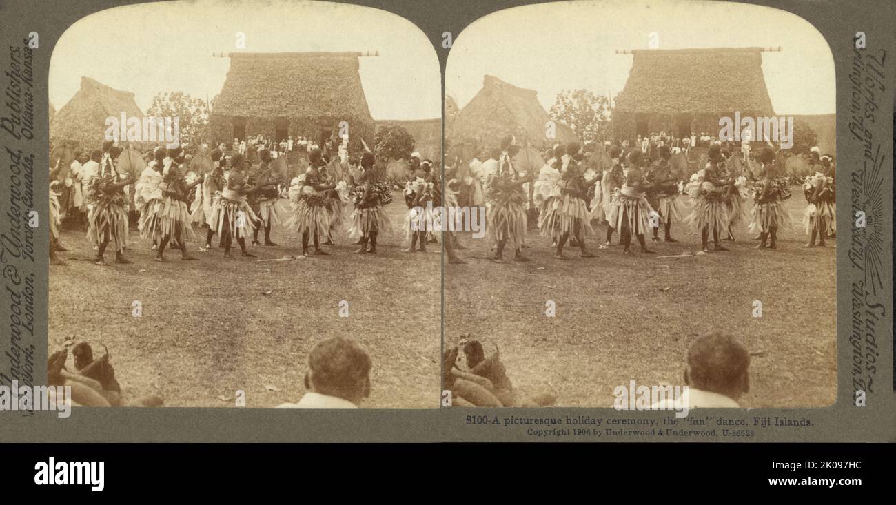 Eine malerische Feiertagszeremonie, der „Fan“-Tanz, Fidschi-Inseln. Von Underwood & Underwood, Verlag, c1905. Stereograph zeigt die Teilnehmer in traditioneller Kleidung im feierlichen „Meke“-Fächertanz, mit Fans, mit großen Gebäuden und Zuschauern im Hintergrund. Stockfoto