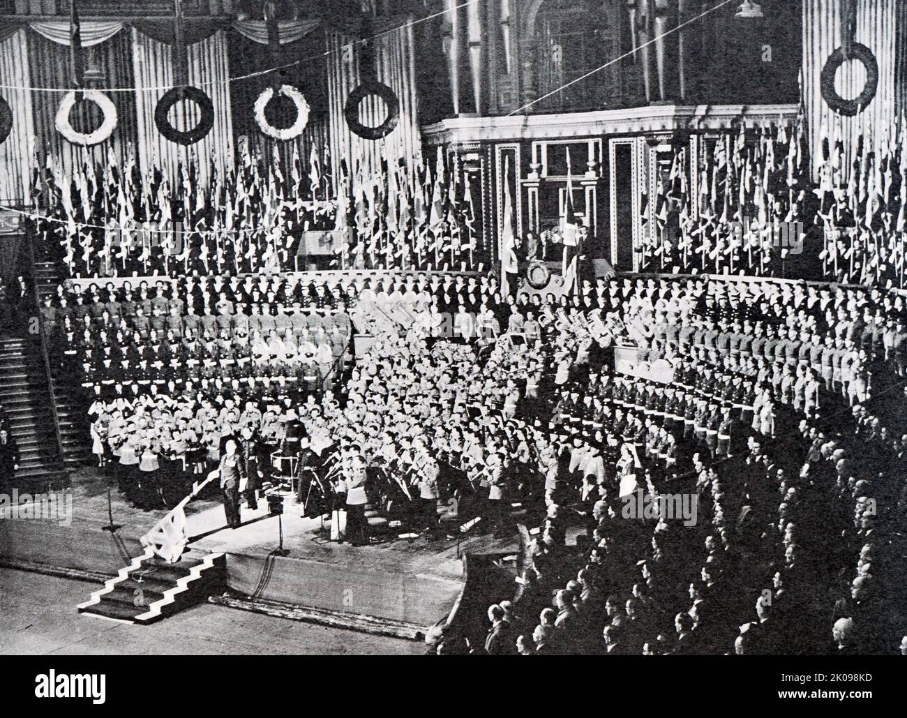British Legion Festival of Remembrance in der Royal Albert Hall während der National Anthem. Als die neu gegründete britische Legion den Mohn als Emblem der Erinnerung annahm und am 11.. November 1921 den ersten britischen Spendenaufruf zum Poppy Day abhielt, tauchte sie auf eine starke emotionale Verbindung zwischen dem Mohn und der Erinnerung, die Veteranenorganisationen anderswo hergestellt hatten, inspiriert von McCraes Gedicht. Stockfoto
