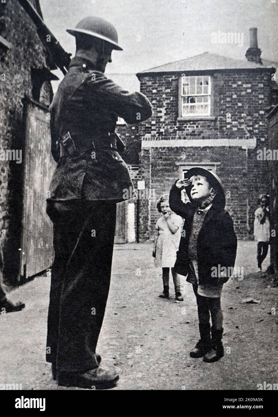 Soldat und Kind in einer Straße während des Zweiten Weltkriegs Stockfoto