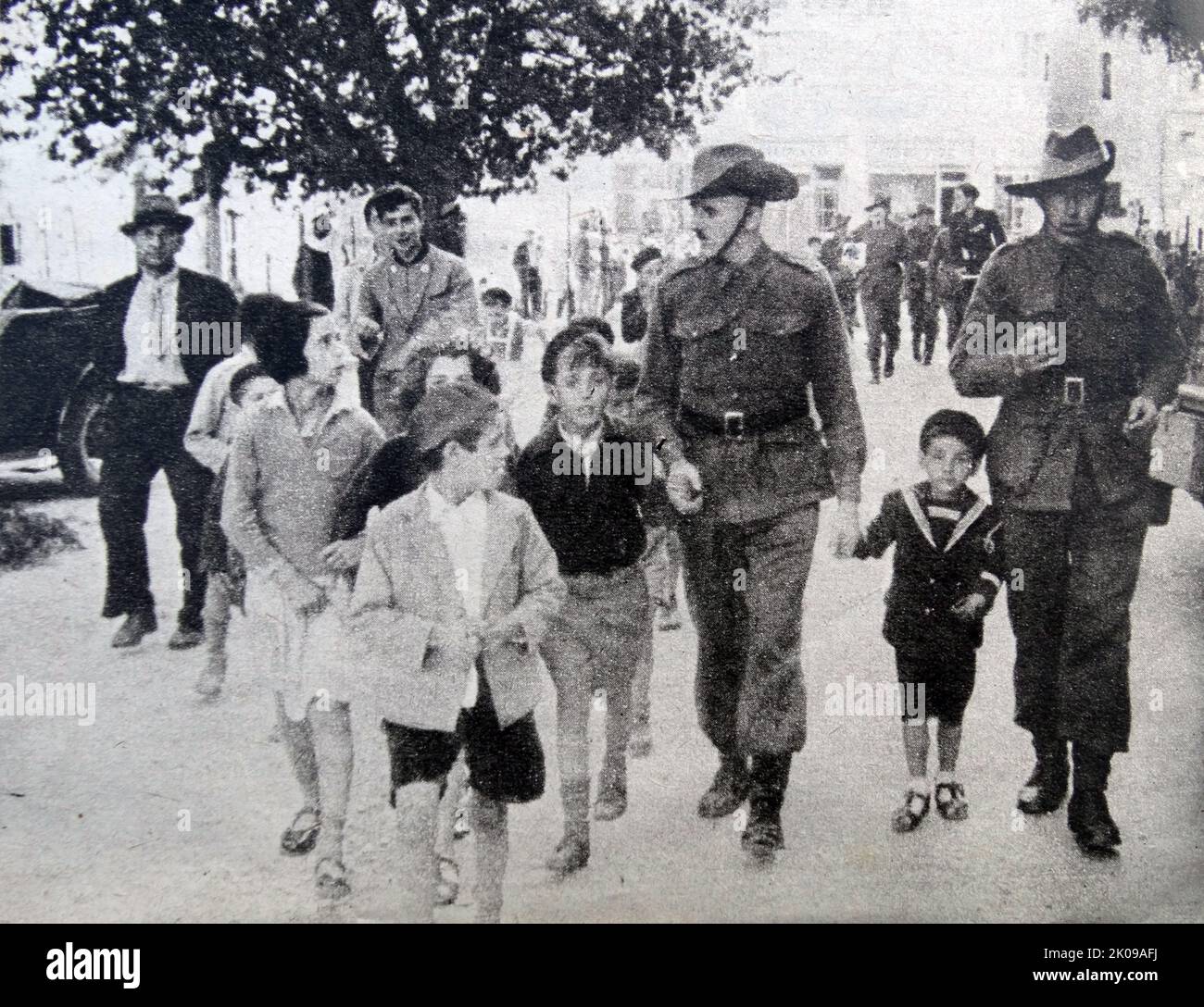 Australische Kinder, die mit britischen Kavallerien und einheimischen Kindern durch die Straßen Jerusalems spazieren. Stockfoto