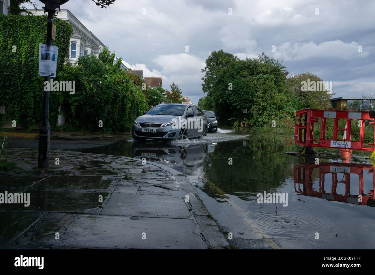 London, England, Großbritannien. 10.. September 2022. Autos, die nach Gewittern von einem überfluteten Ufer der Themse in die Chiswick Lane einbiegen. Cristina Massei/Alamy Live News Stockfoto