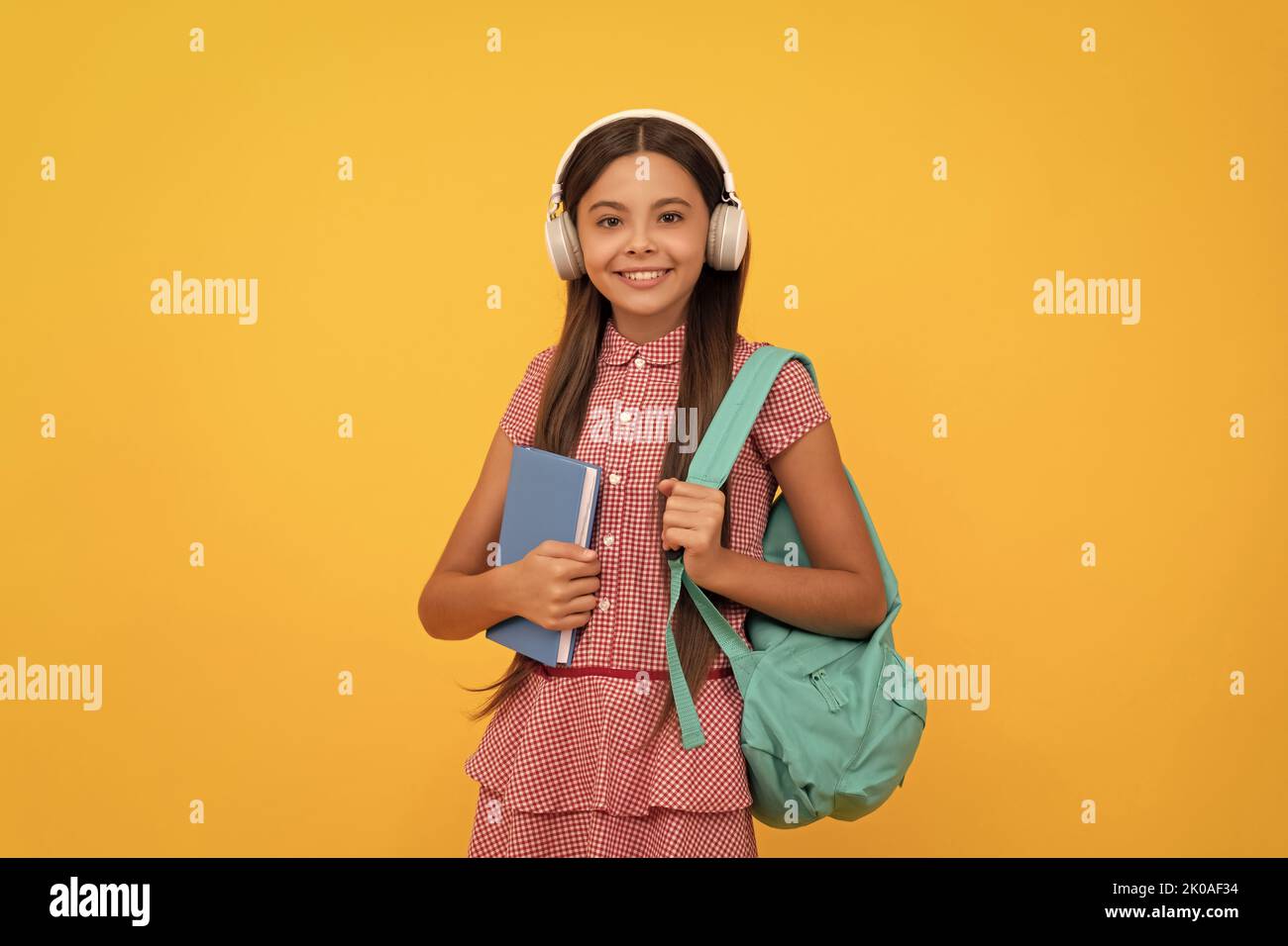 Happy School Teenager Mädchen in Kopfhörer tragen Rucksack und Arbeitsbuch, elearning Stockfoto