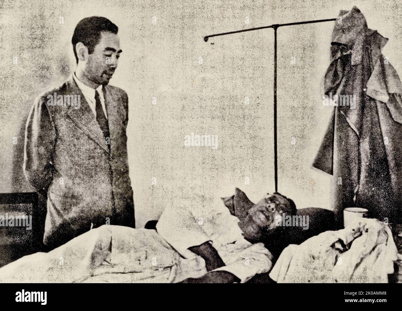 Zhou Enlai kondoliert den verletzten Vertretern des Krankenhauses. Abgebildet ist Zhou Enlai vor Ma Xuluns Bett. MA war ein chinesischer Politiker, Aktivist und Linguist. Stockfoto