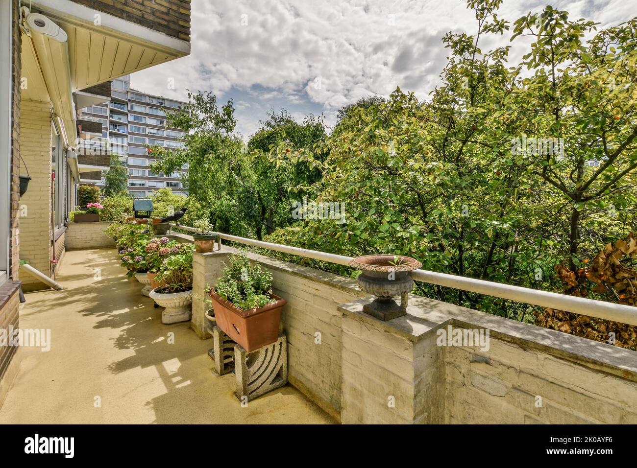 Einfacher kleiner Balkon mit kleinem Garten in der Nähe des Fensters Stockfoto