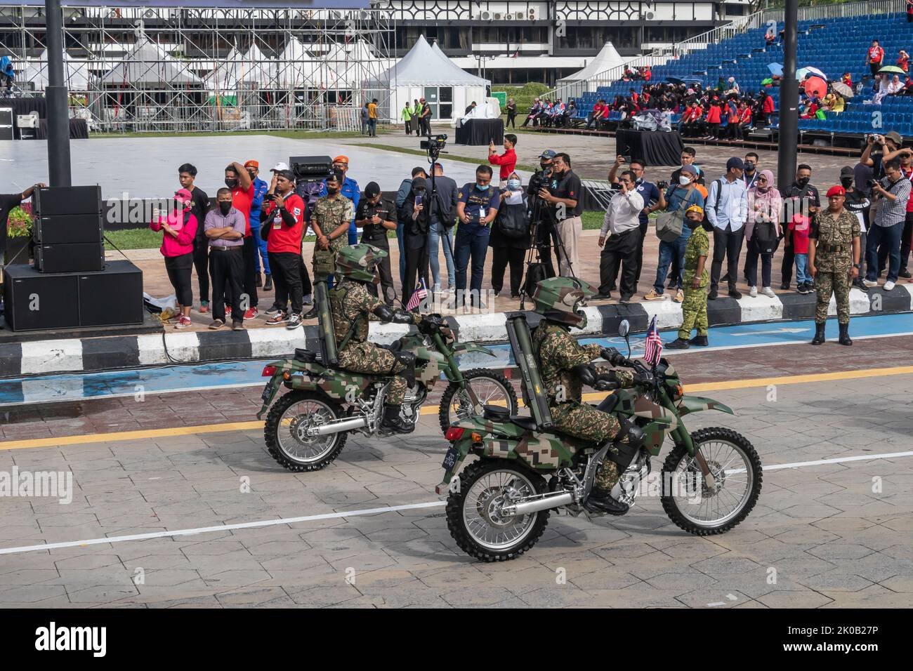 Mitarbeiter der malaysischen Armee mit Waffen und Kampfausrüstung fahren während der Parade zum Nationalfeiertag 65. in Kuala Lumpur, Malaysia, auf einem Scrambler-Fahrrad oder einem Dirt Bike. Stockfoto
