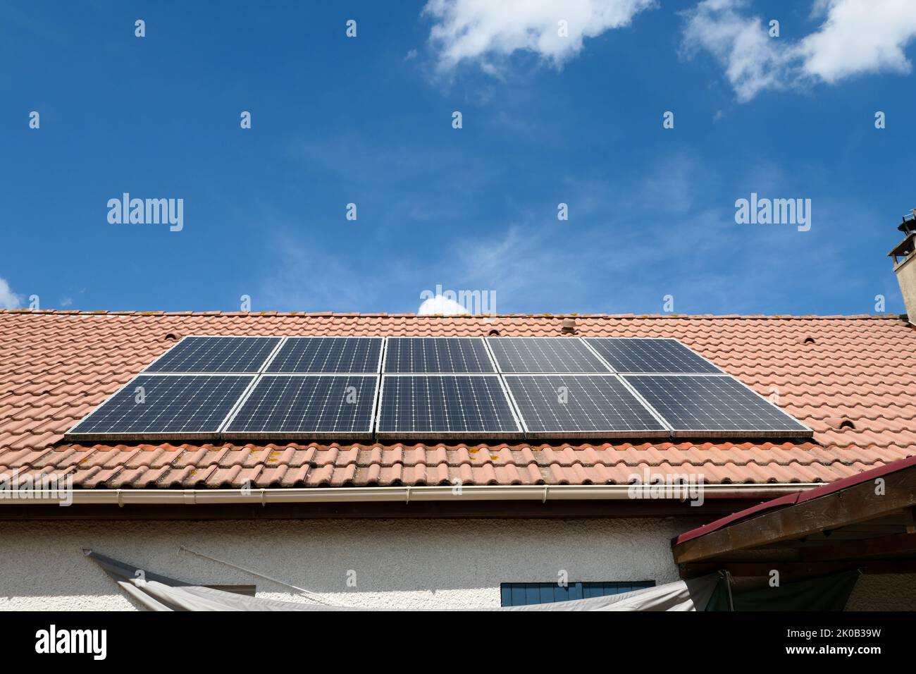 Photovoltaik-Paneele auf dem Dach eines Hauses installiert. Sonnenkollektoren auf einem Dach. Stockfoto