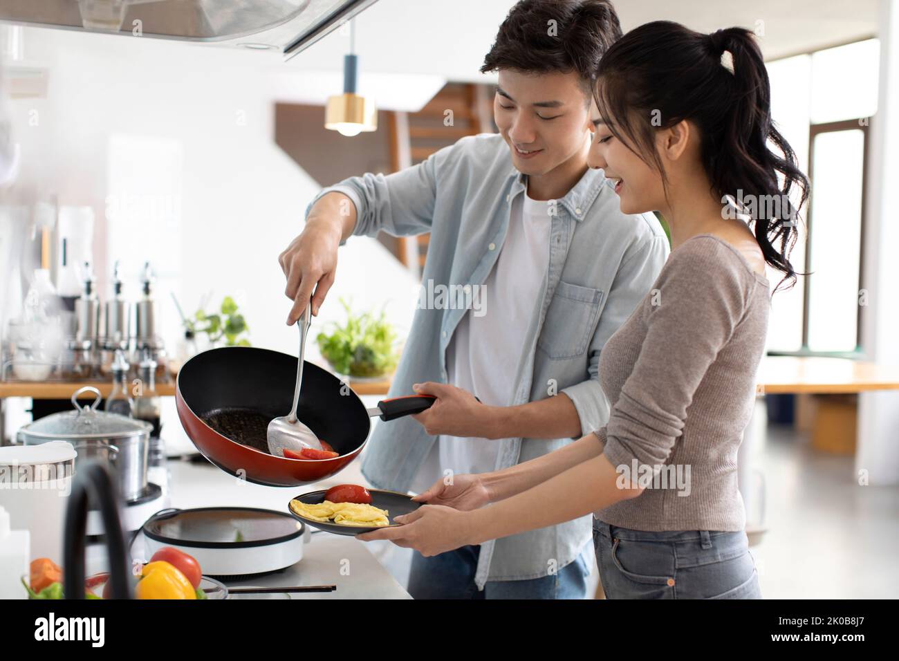 Glückliche junge chinesische paar in Küche Stockfoto