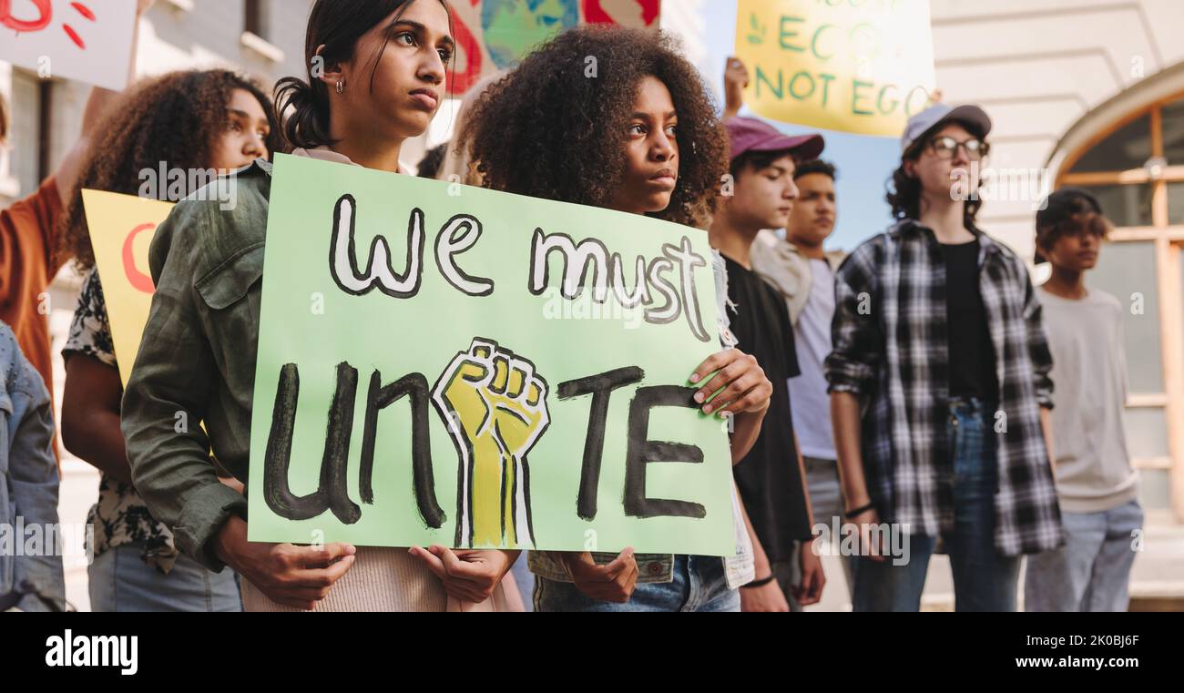 Klimaangriff in der Stadt. Mit Spruchbändern und Plakaten marschieren verschiedene junge Menschen für Klimagerechtigkeit. Eine Gruppe multikultureller Jugendaktivisten protestiert Stockfoto