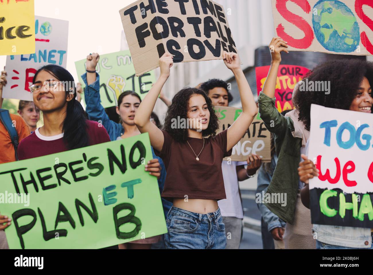 Jugendliche der Generation Z marschieren gegen den Klimawandel und die globale Erwärmung. Multikulturelle Klimaaktivisten protestieren mit Plakaten und Transparenten. Gruppe Stockfoto