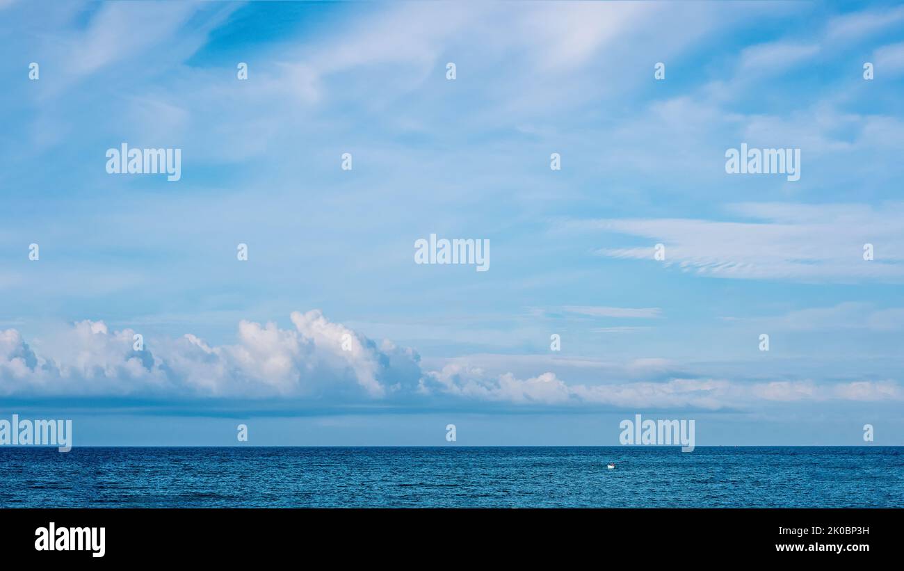 PANORAMA echte Foto natürliche Wolkenlandschaft Tapete. Schöne weiße flauschige Cumulus Wolken Sommer blauen Himmel ruhigen Meer Horizont Skyline. Konzept Relax-Stimmung Stockfoto