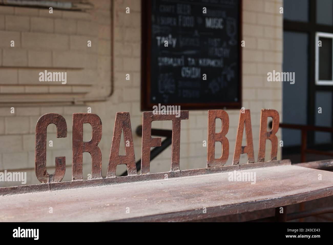 Iron signboard Craft Bar und Barcounter. Eintritt zu einem Craft Beer Establishment. Verwackelte Backsteinmauer im Hintergrund. Stockfoto