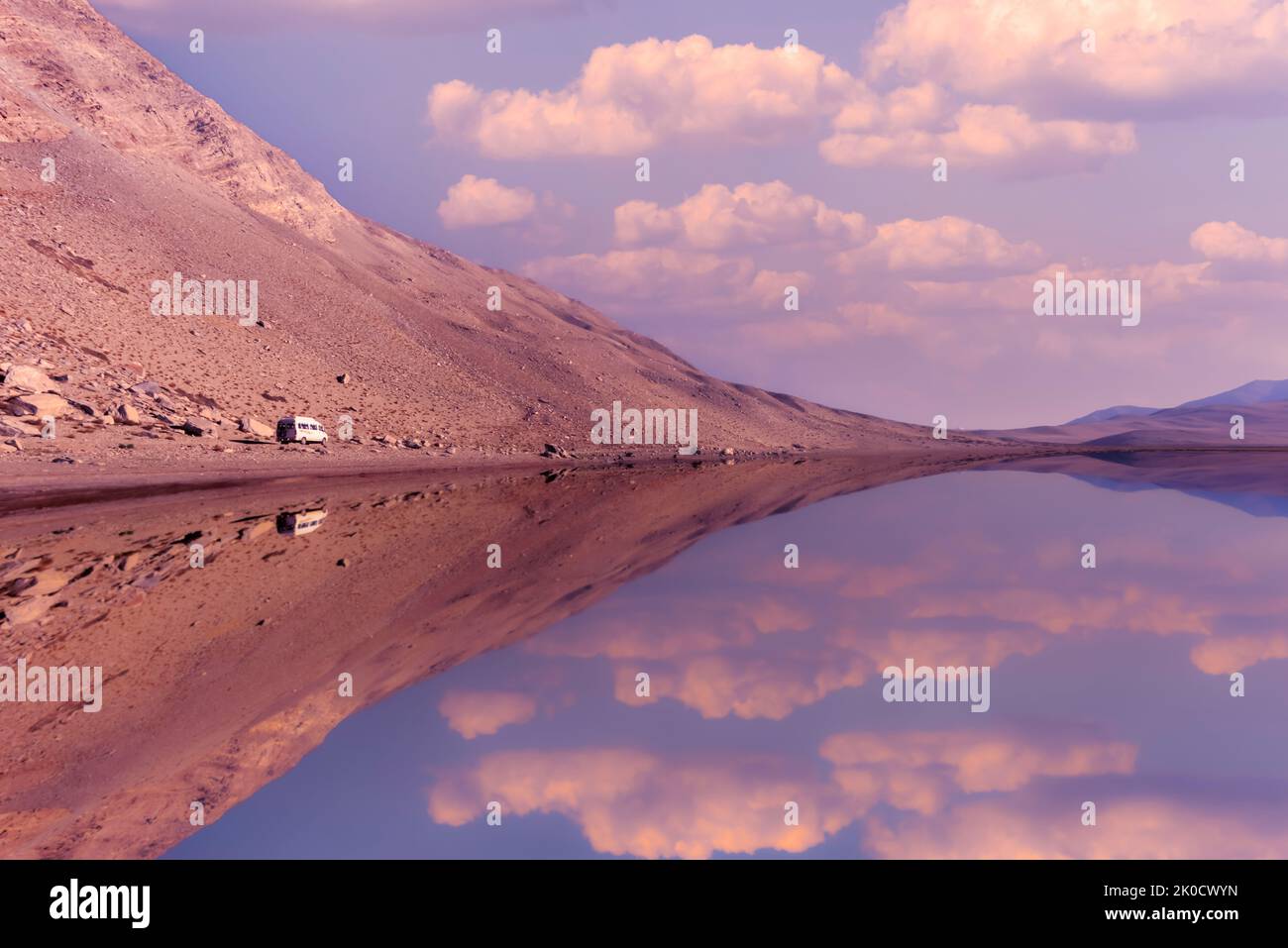 Reflexion von Wolken, einem Minibus und einer Bergkette in einem der ruhigen Seen im Tso Moriri Feuchtgebiet in Changthang in Ladakh, Indien. Stockfoto