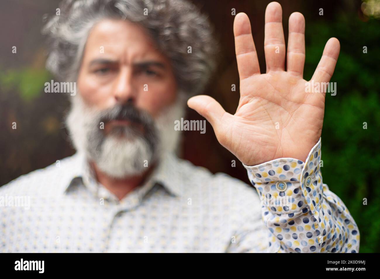 Bärtiger Mann in lässiger Kleidung, der mit der Hand eine Stoppgeste macht Stockfoto