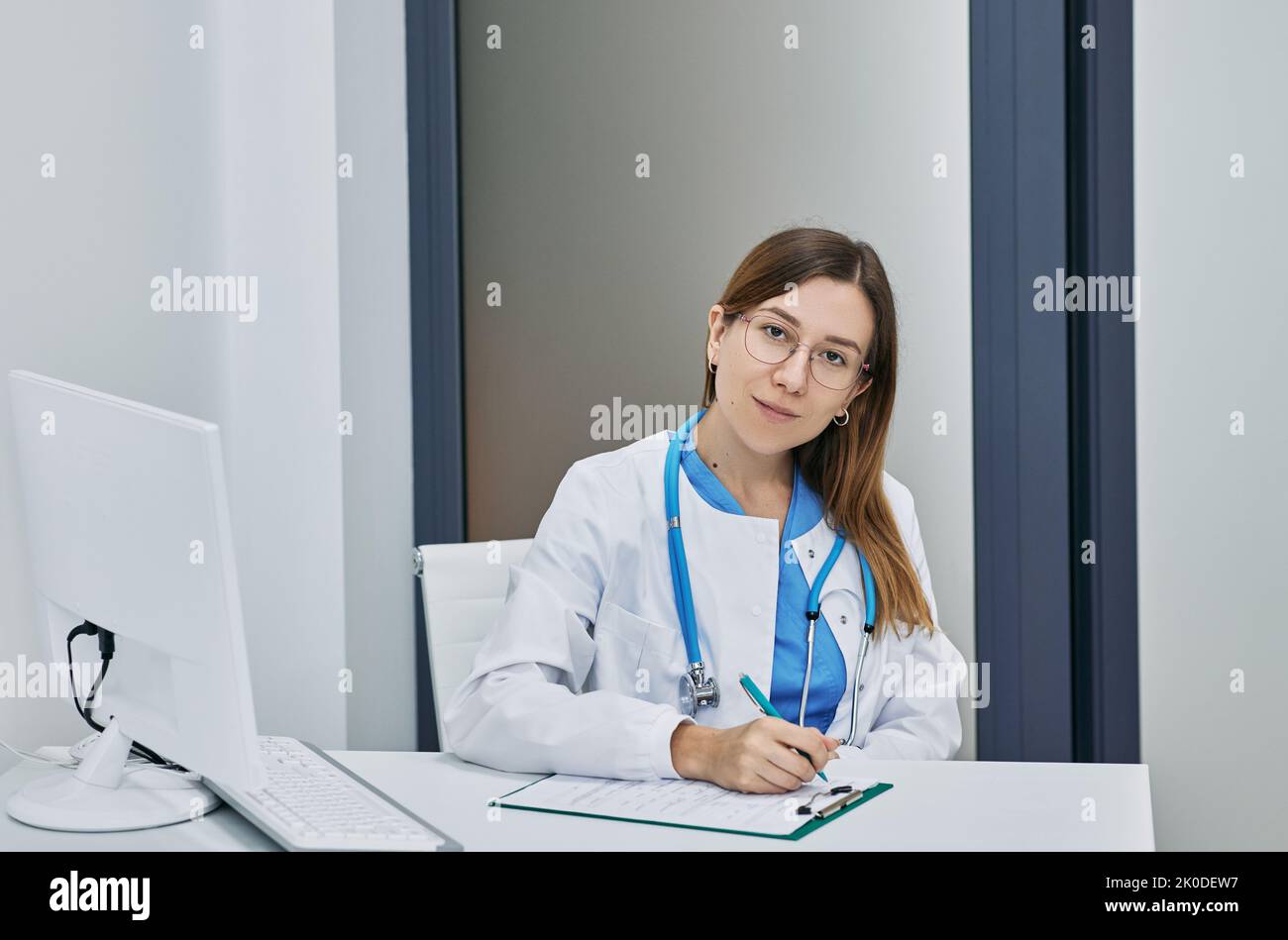 Freundliche Hausärztin in medizinischer Uniform sitzend in der modernen medizinischen Klinik, Porträt. Arztberuf Stockfoto