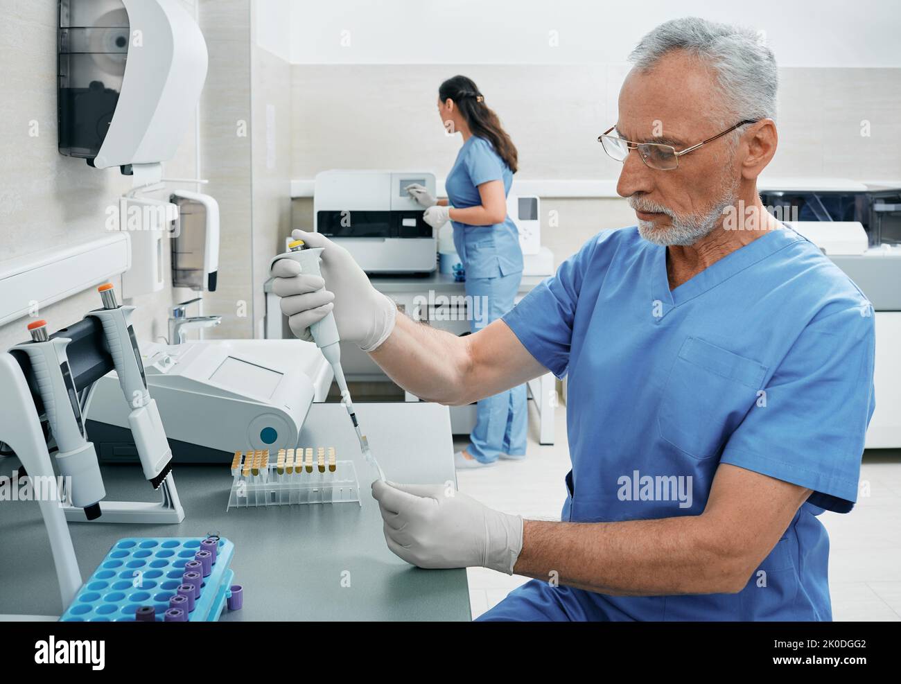 Labortechniker, die im medizinischen Labor arbeiten und mit moderner Technologie an Blutproben forschen Stockfoto