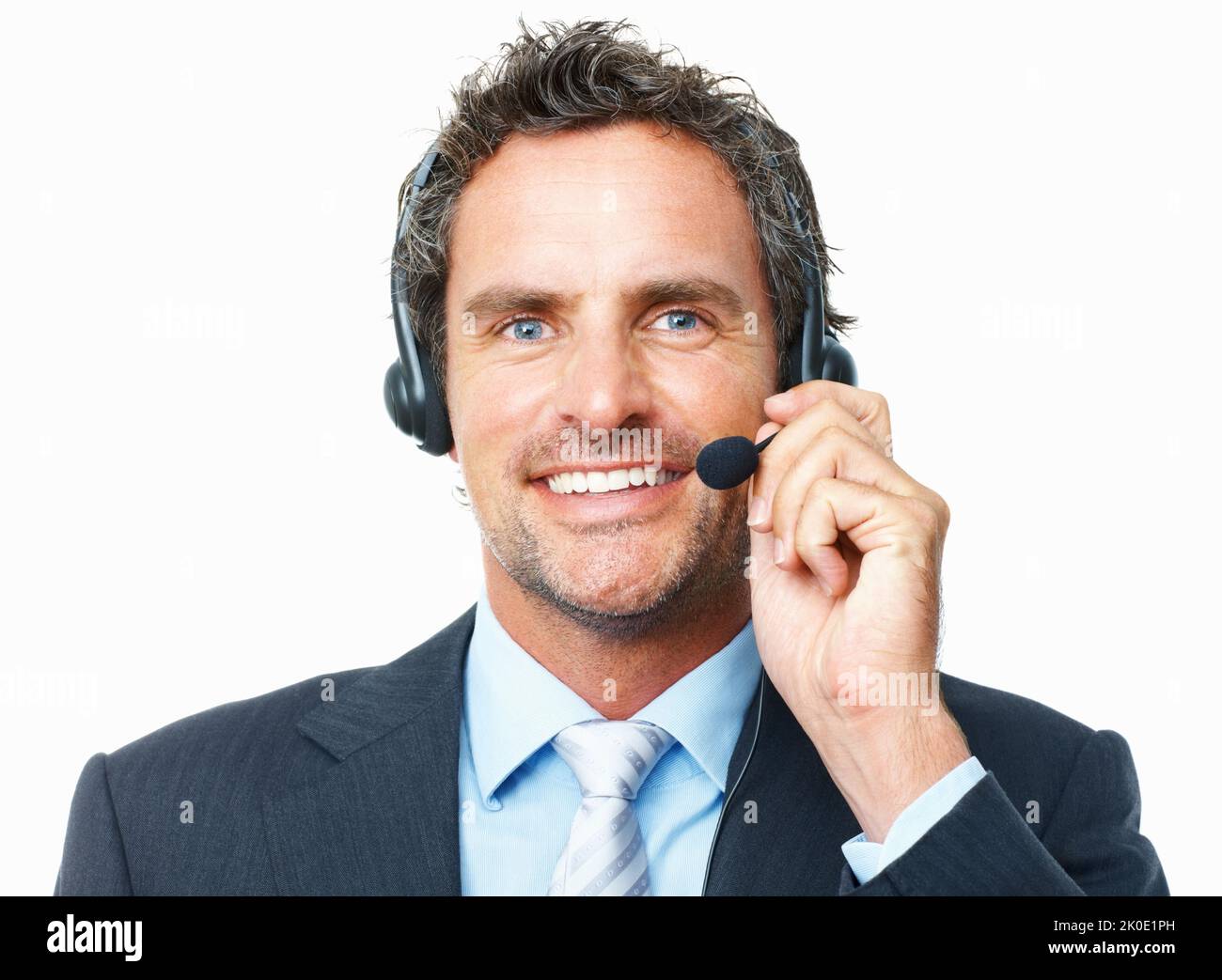 Lächelnder Bediener. Nahaufnahme eines intelligenten, reifen Bedieners, der auf einem Headset vor weißem Hintergrund spricht. Stockfoto