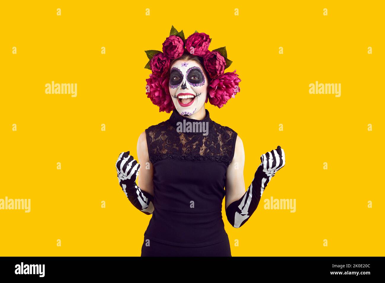 Cheefrul verrückte Frau im Halloween Kostüm mit Kranz aus rosa Blumen und gruseligem Make-up. Stockfoto