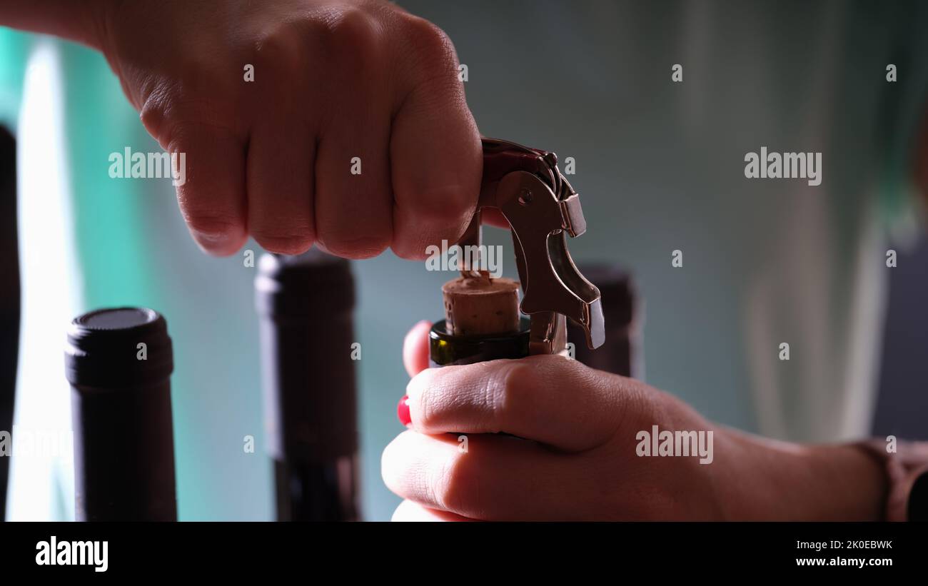 Öffnen einer Flasche Wein auf dunklem Hintergrund Stockfoto