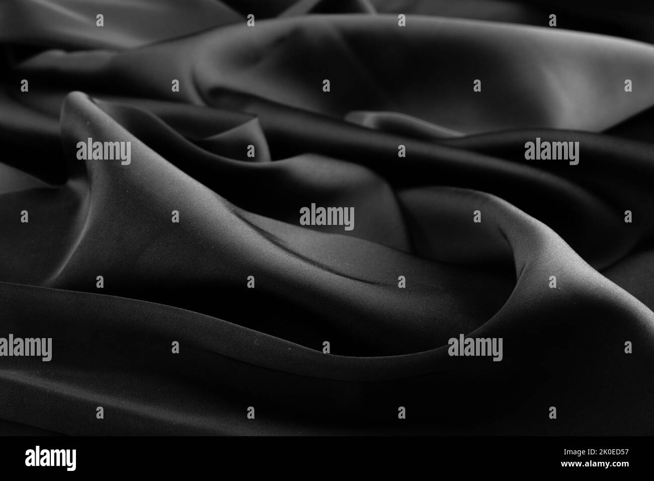 Falten aus schwarzem Seidenstoff. Stockfoto