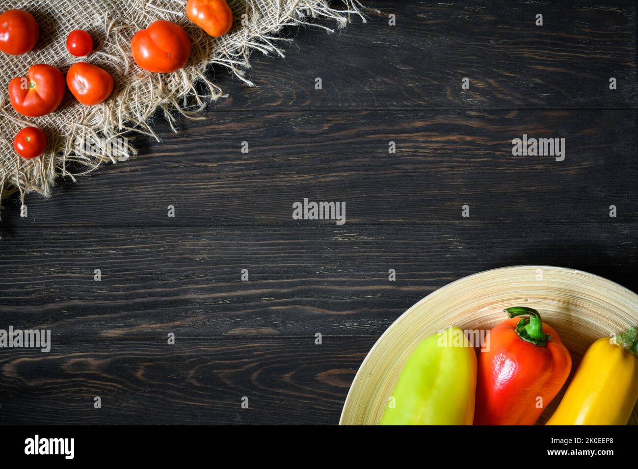 Gemüse auf Holztisch Hintergrund, Draufsicht auf Bio-Vollfutter. Paprika, Zucchini und kleine Tomaten auf rustikalen Holzplanken mit Platz, flach Stockfoto