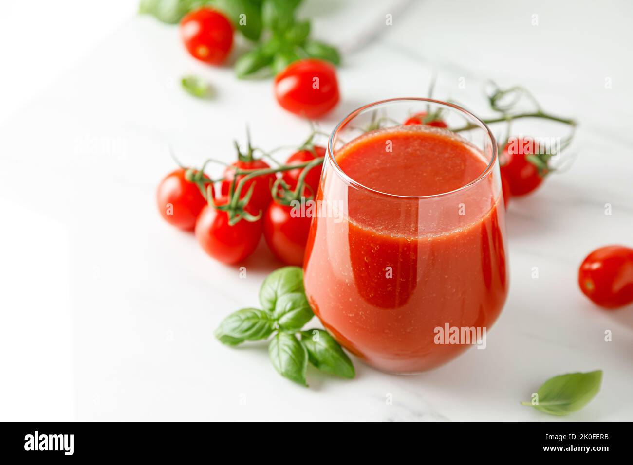 Tomatensaft im Glas und frische Tomaten Stockfoto