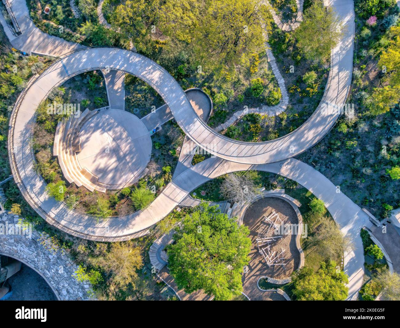 Leerer Park in Austin, Texas mit spiralförmigem Betonweg mit kleinem Amphitheater in der Mitte. Luftaufnahme eines Parks, der von Pflanzen und Bäumen umgeben ist Stockfoto