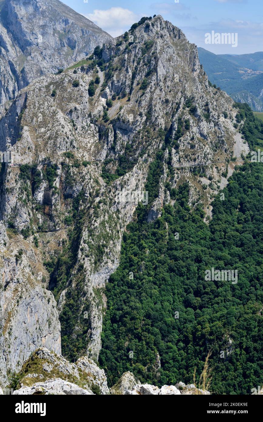 Schiere Felswand mit Blick auf den Fußweg von Urdon nach Tresviso, Picos de Europa. Das kleine Gebäude ist Teil des Wasserkraftwerks. Stockfoto