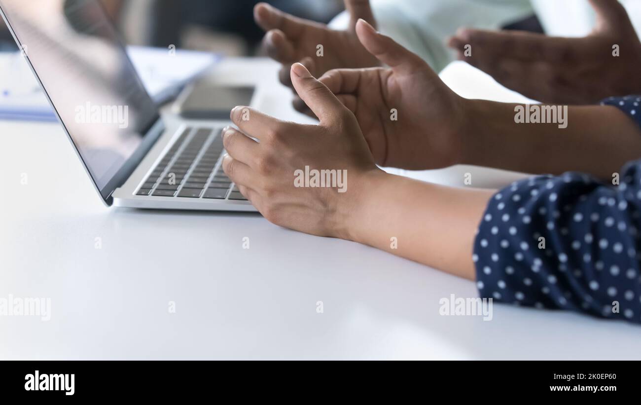 Hände von männlichen und weiblichen Mitarbeitern, die am Arbeitstisch sitzen Stockfoto