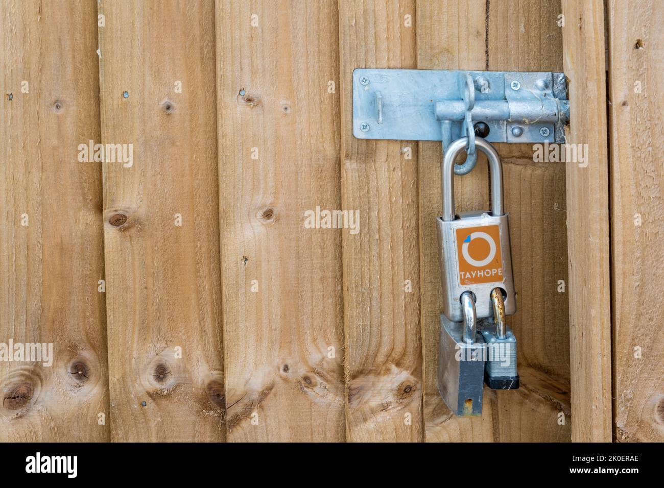 Ein doppeltes Vorhängeschloss, mit dem zwei Personen es mit unterschiedlichen Schlüsseln öffnen können. Stockfoto