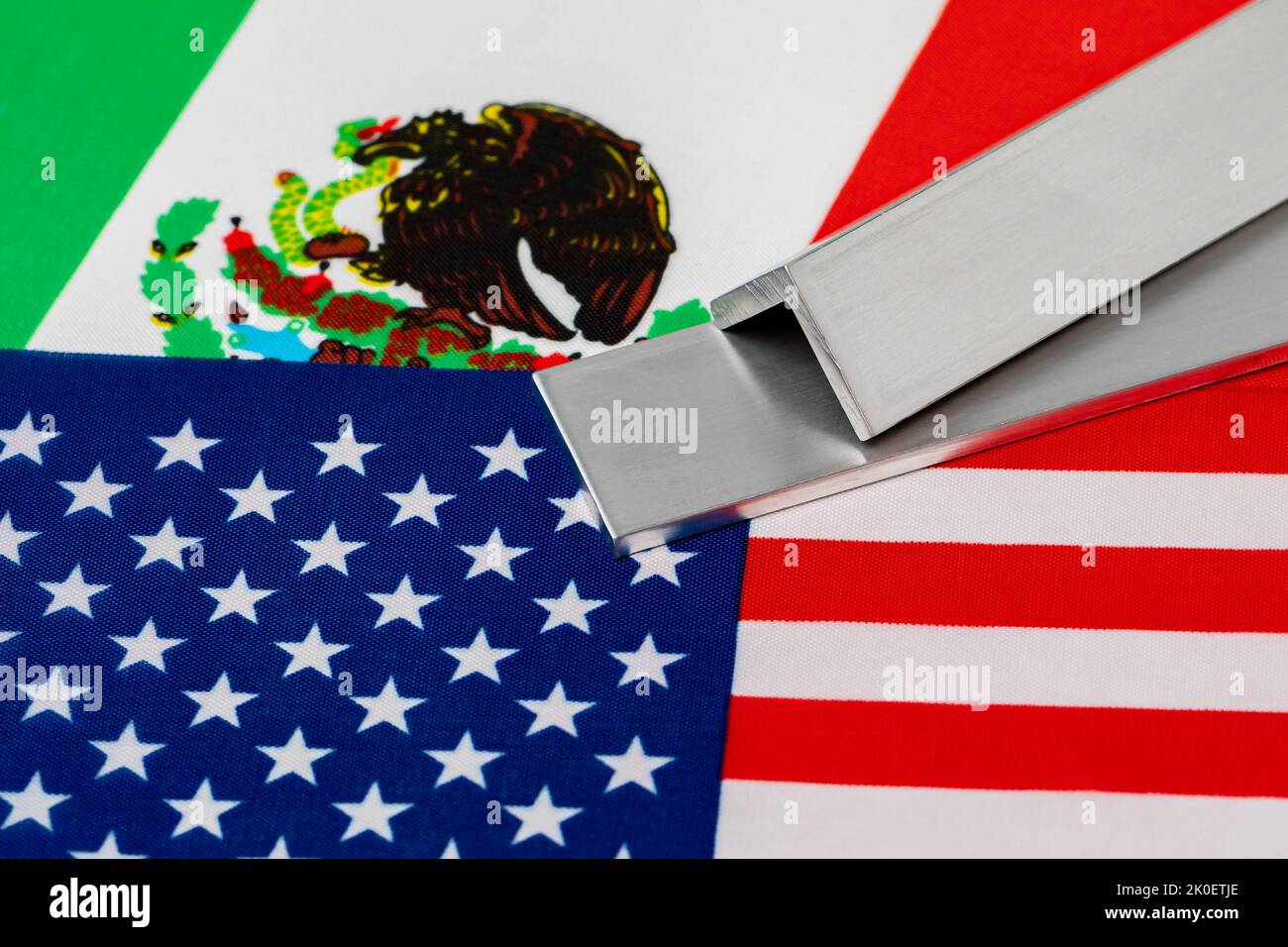 Aluminium-Metalllager auf Flaggen von Mexiko und den Vereinigten Staaten von Amerika. Konzept von Handelskrieg, Zöllen, fairem Handel und Stahlindustrie. Stockfoto