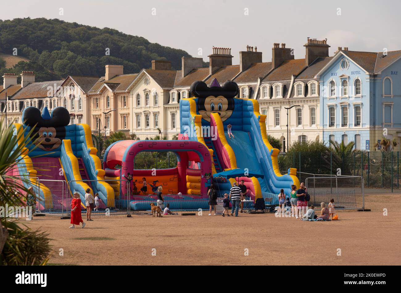 Teignmouth, Devon, England, Großbritannien. 2022. Strandwohnungen und Kinderspielplatz auf getrocknetem Gras während der Hitzewelle in Teignmouth, einem beliebten Badeort. Stockfoto