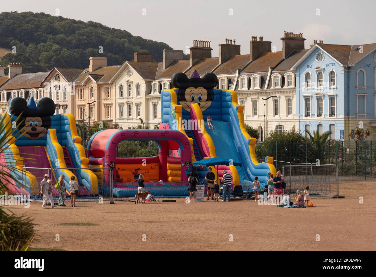 Teignmouth, Devon, England, Großbritannien. 2022. Strandwohnungen und Kinderspielplatz auf getrocknetem Gras während der Hitzewelle in Teignmouth, einem beliebten Badeort. Stockfoto