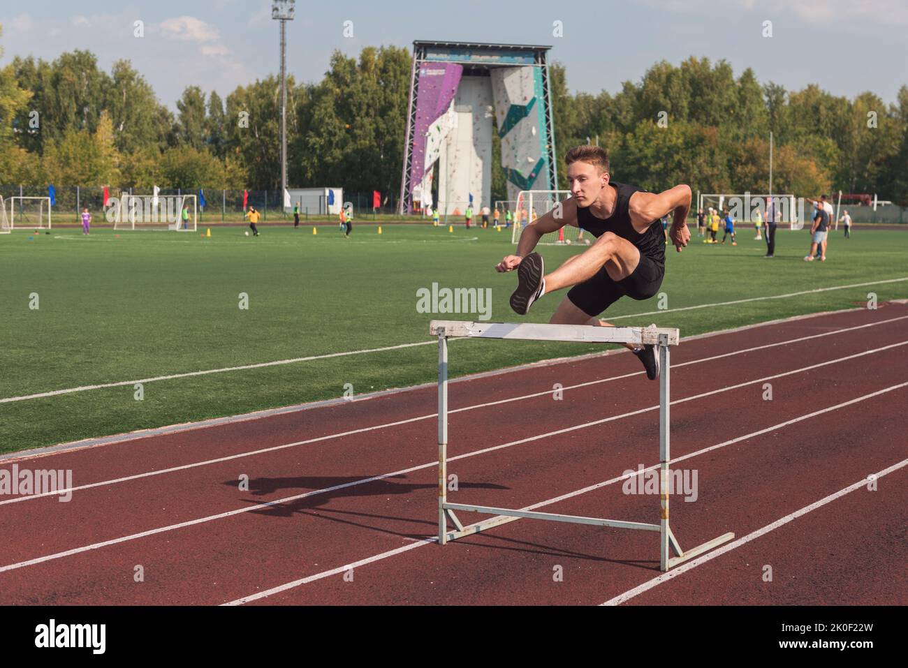 Junger Mann Athlet Runnner läuft Hürden im Stadion im Freien Stockfoto