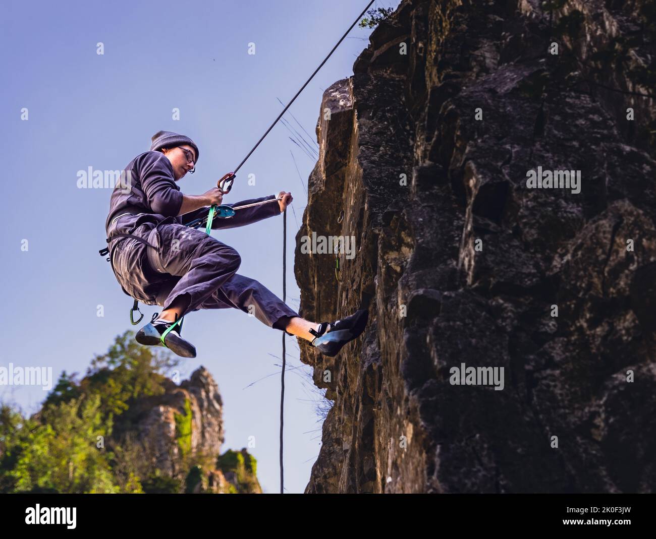 Klettern an Felswänden mit Seilzugangstechnik in der Sonne im Freien Stockfoto