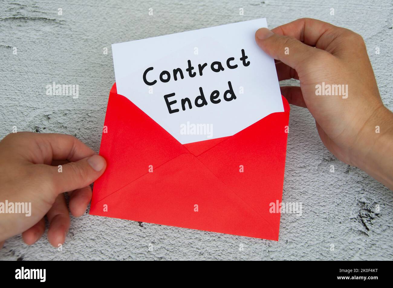 Vertragstext auf weißem Notizblock mit rotem Umschlaghintergrund. Beschäftigungskonzept. Stockfoto