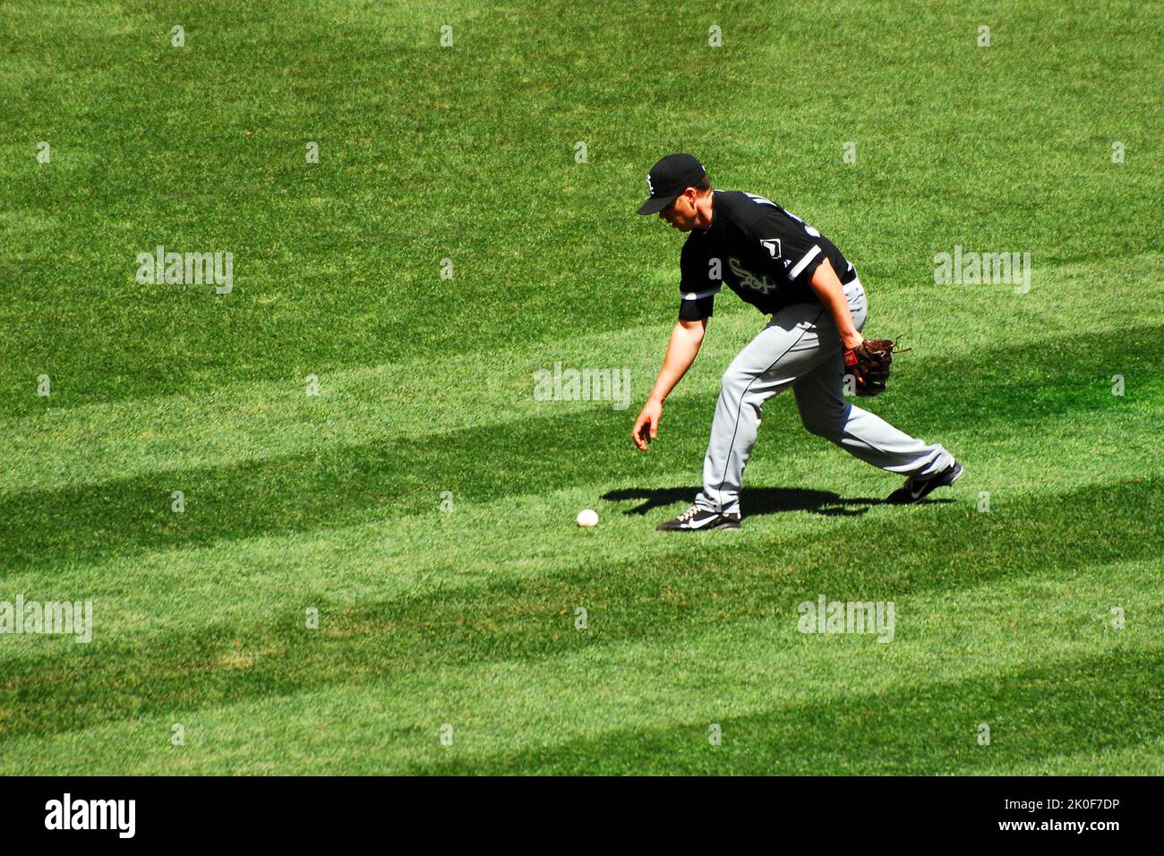 Ein Chicago White Sox Fielder nimmt den Ball auf, nachdem er während eines Baseballspiels einen Fehler begangen hat Stockfoto