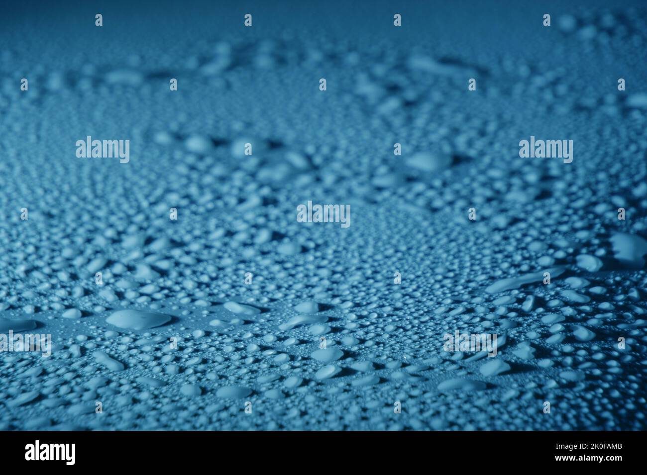 Blaue Wassertropfen, Tau auf glatter Oberfläche Stockfoto