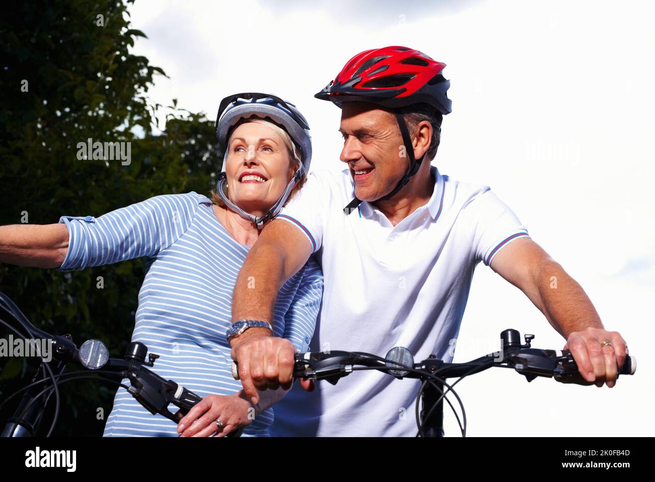Sportlich reifer Mann und Frau, die an einem sonnigen Tag Fahrrad fahren. Porträt eines sportlich reifen Mannes und einer Frau, die an einem sonnigen Tag Fahrrad fahren. Stockfoto