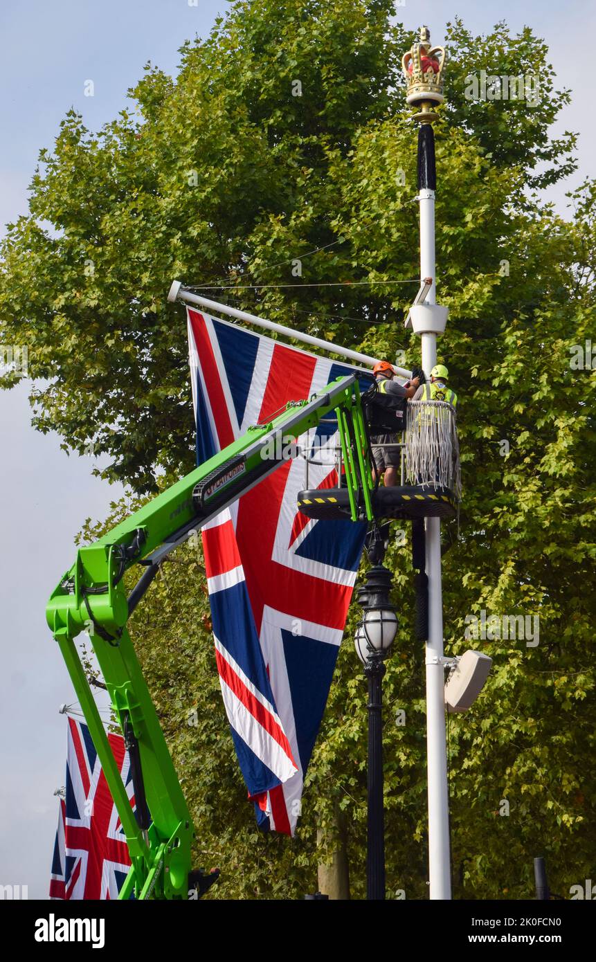 Arbeiter installieren Union Jacks entlang der Mall, die nach dem Tod von Königin Elizabeth II. Zum Buckingham Palace führt Die Königin starb am 8.. September im Alter von 96 Jahren. Stockfoto