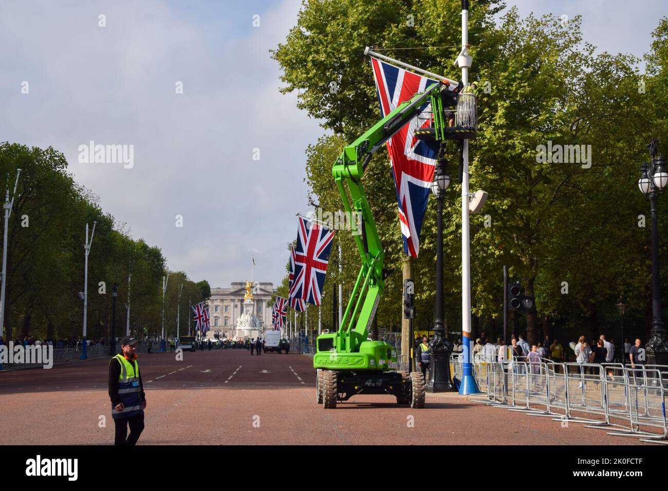 Arbeiter installieren Union Jacks entlang der Mall, die nach dem Tod von Königin Elizabeth II. Zum Buckingham Palace führt Die Königin starb am 8.. September im Alter von 96 Jahren. Stockfoto