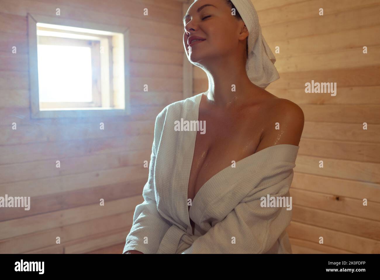 Schöne junge Frau, die sich in der finnischen Sauna entspannt Stockfoto
